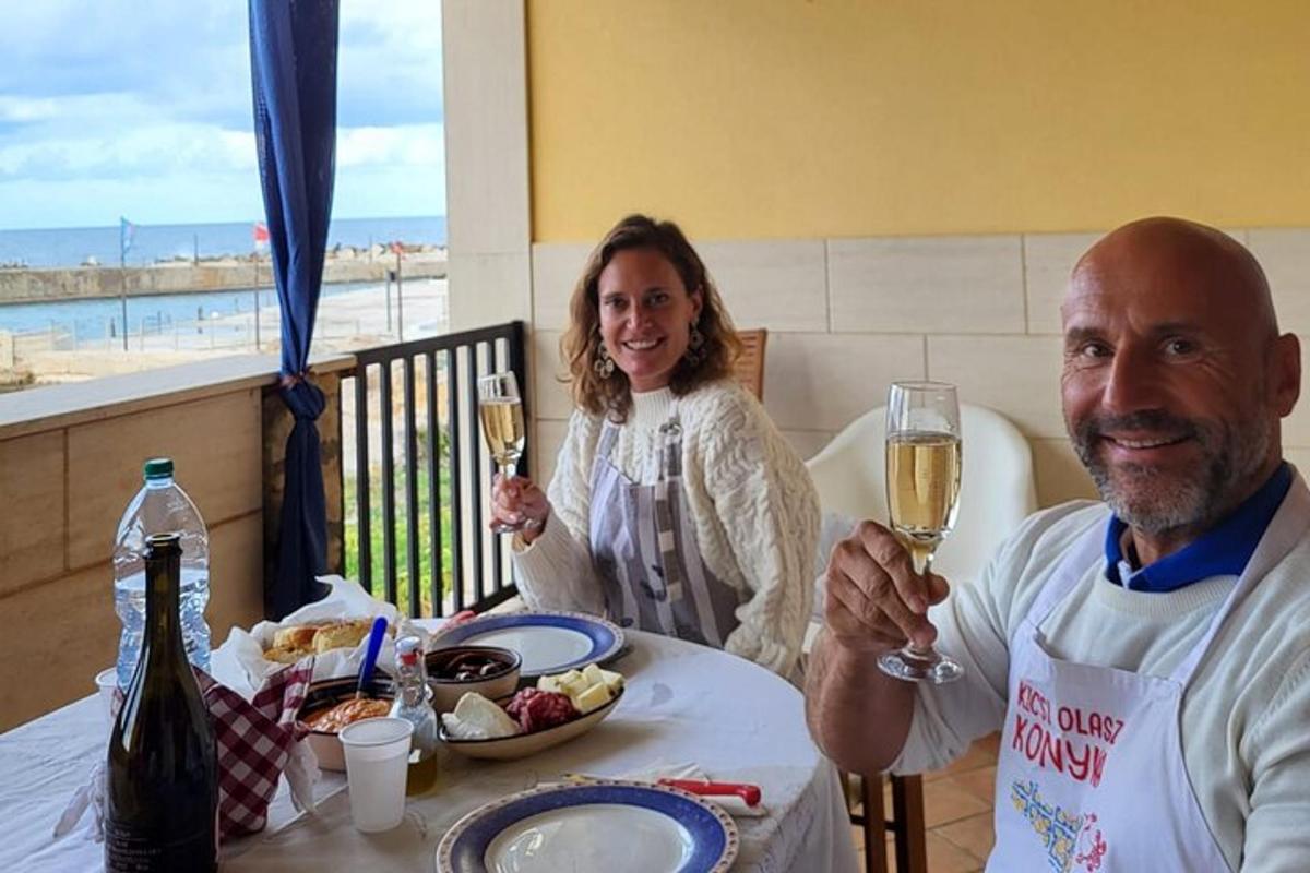 un home i una dona asseguts a una taula amb copes de vi