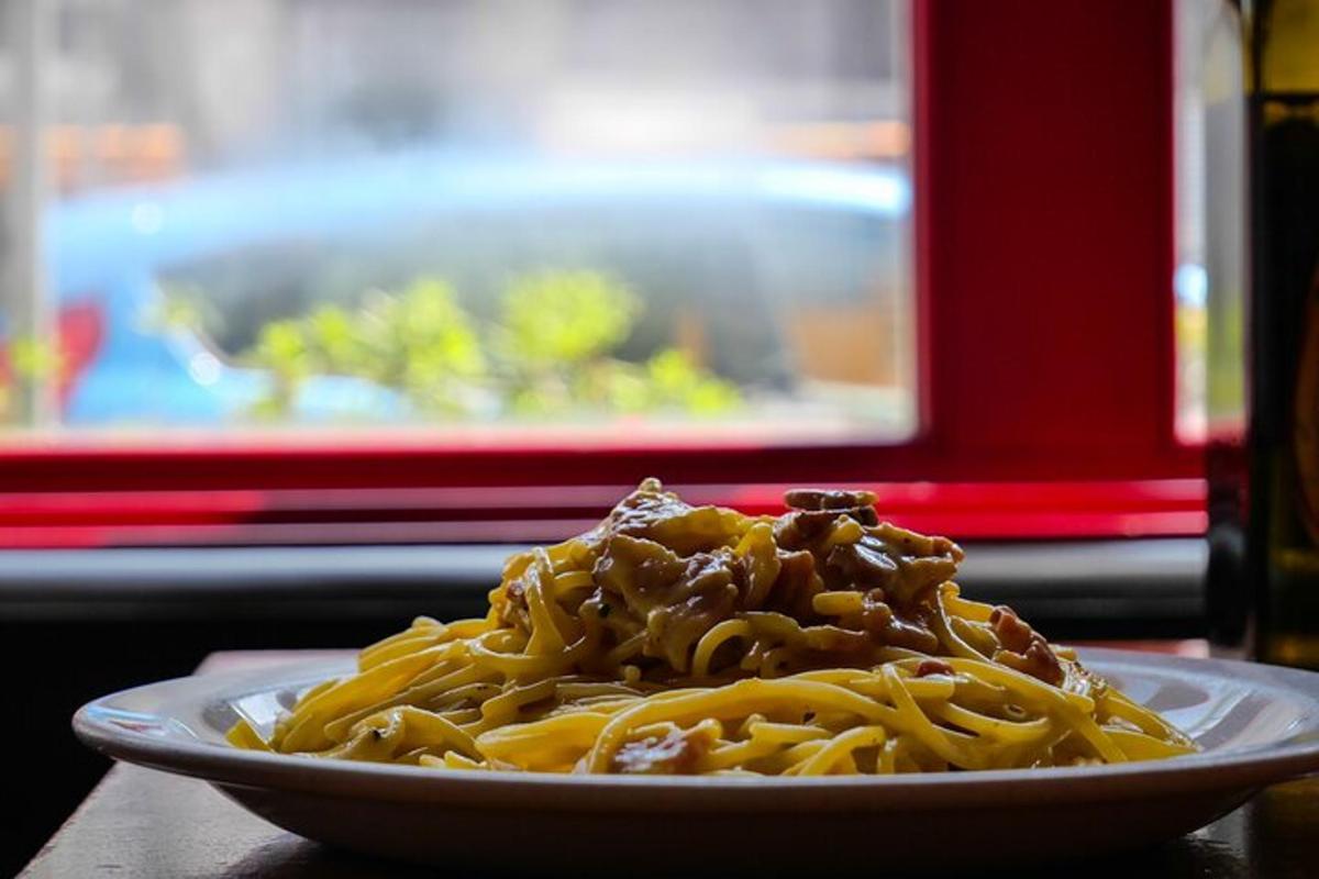 un piatto di pasta con carne e salsa su un tavolo