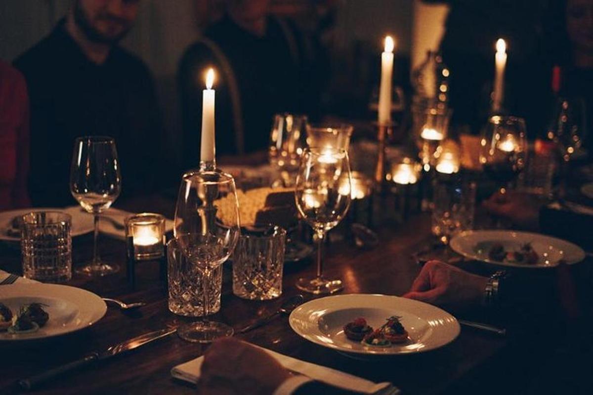 a table with glasses and plates of food and candles
