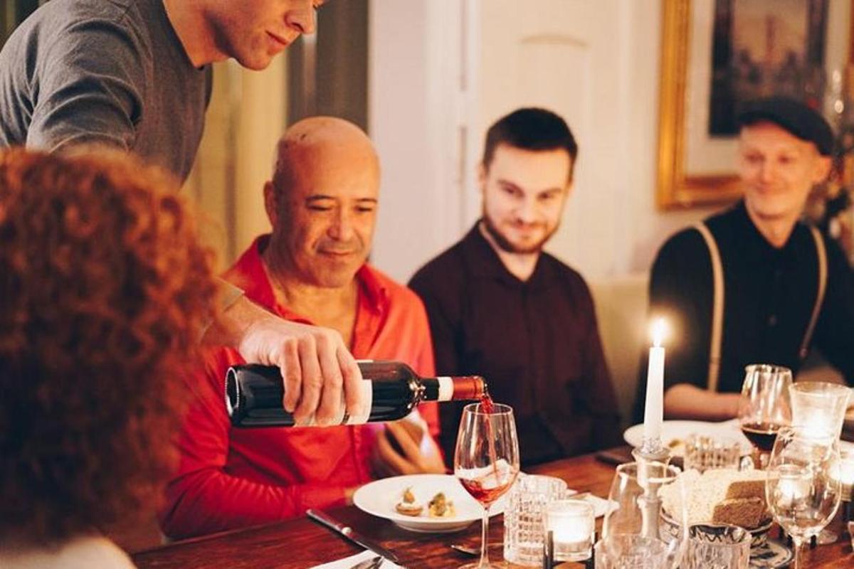a man pouring a glass of wine at a table