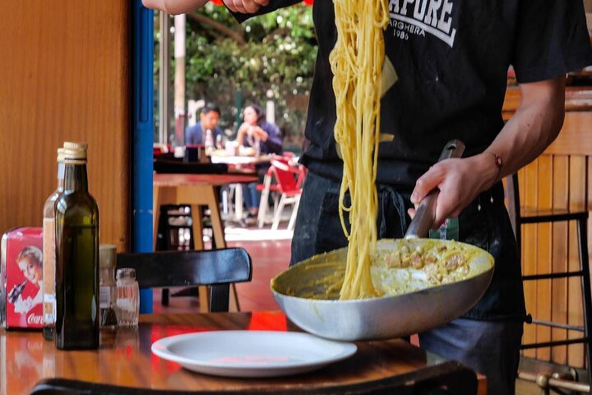 Un hombre está preparando un plato de espaguetis.