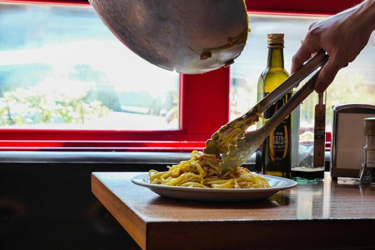 una persona sta spalmando la salsa su un piatto di pasta