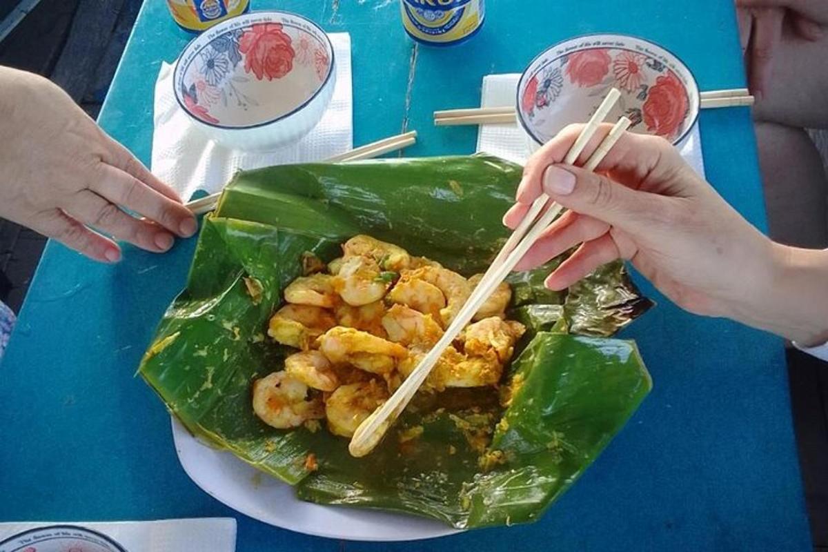 dua orang makan makanan dengan penyepit di atas meja