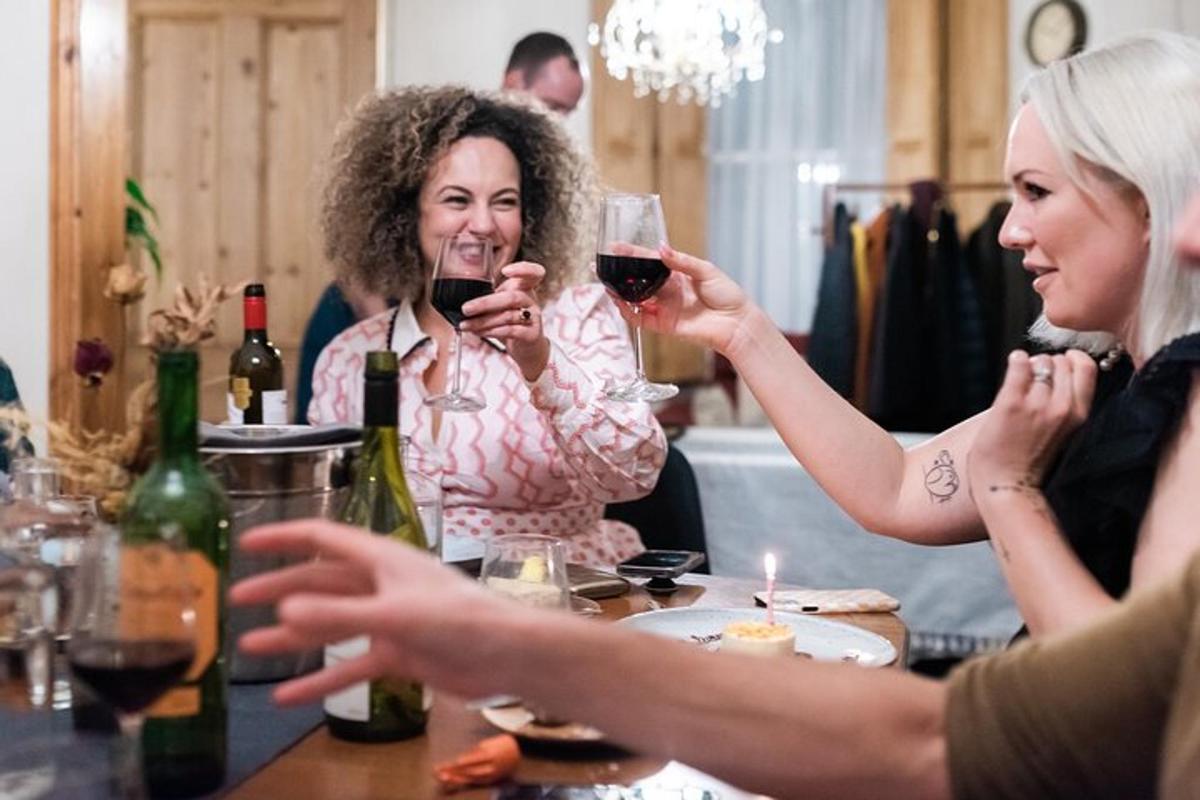 un grup de femei așezate la o masă, bând vin