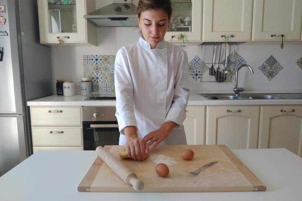 Una mujer en una cocina preparando huevos en una tabla de cortar.