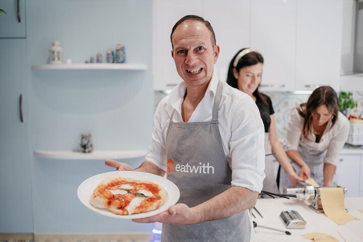 um homem em uma cozinha segurando um prato de comida