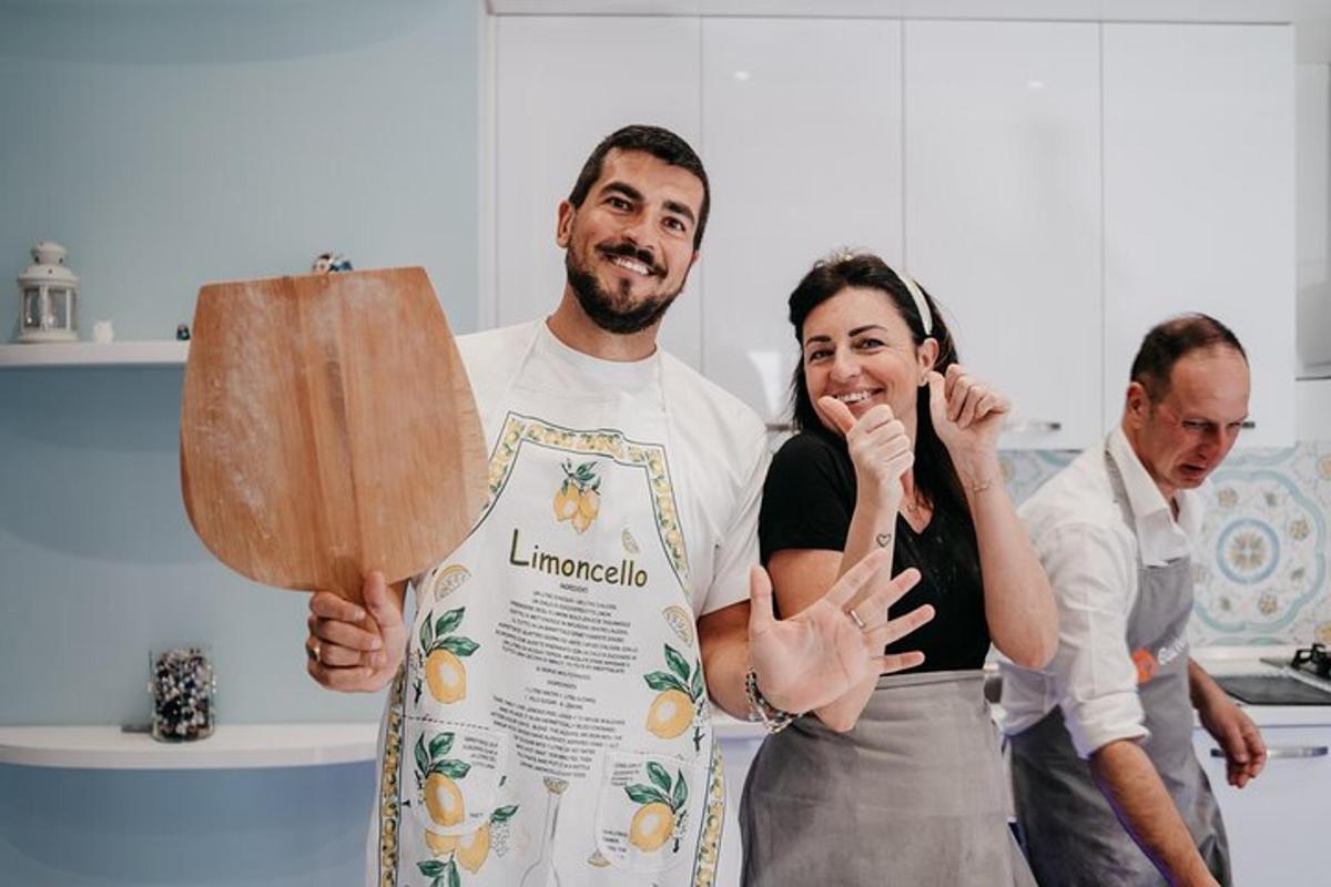 un home i una dona en una cuina sostenint una pala de fusta