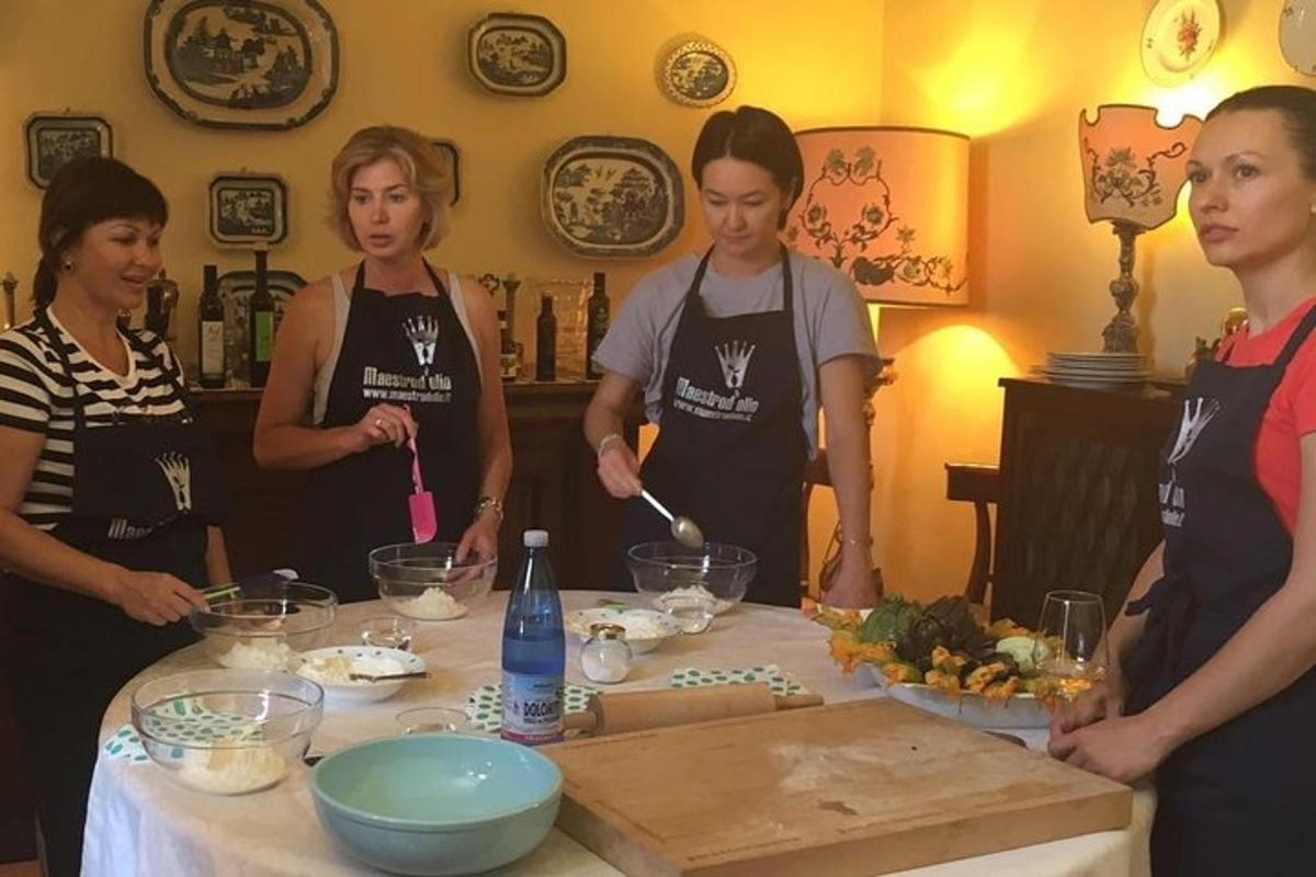 Un grupo de mujeres de pie alrededor de una mesa preparando comida.