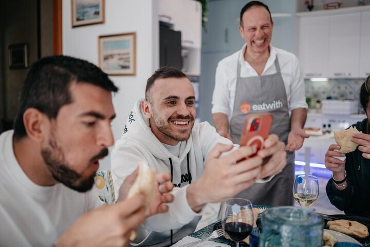 um grupo de homens sentados ao redor de uma mesa com um telefone celular