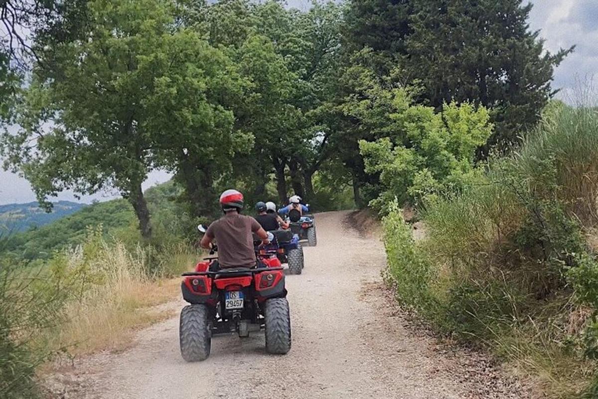 skupina lidí jedoucích na motorkách po nezpevněné cestě