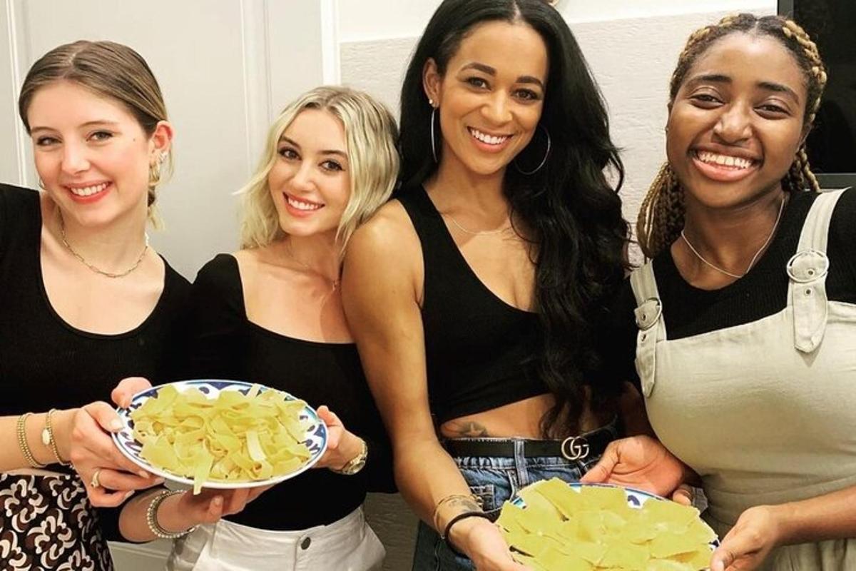 un gruppo di tre donne che tengono in mano un piatto di cibo