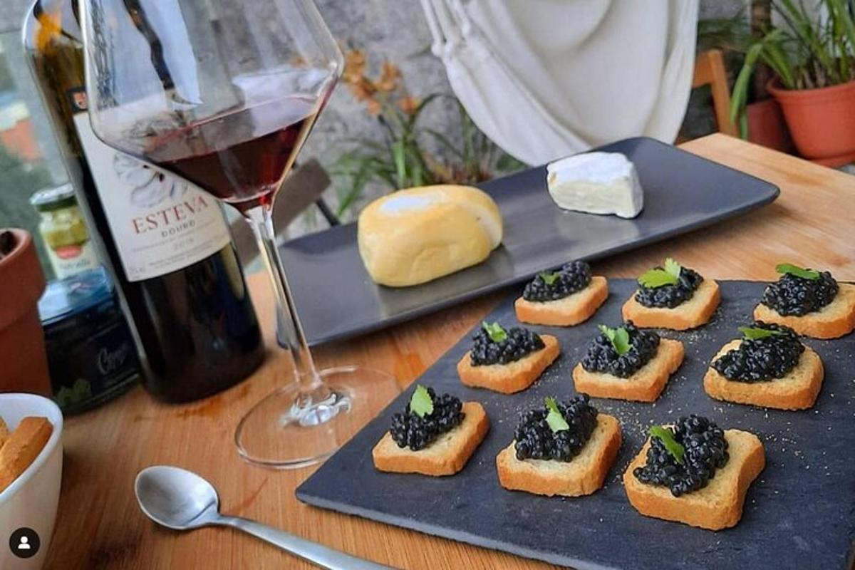 ein Teller mit Brot und Käse und einem Glas Wein