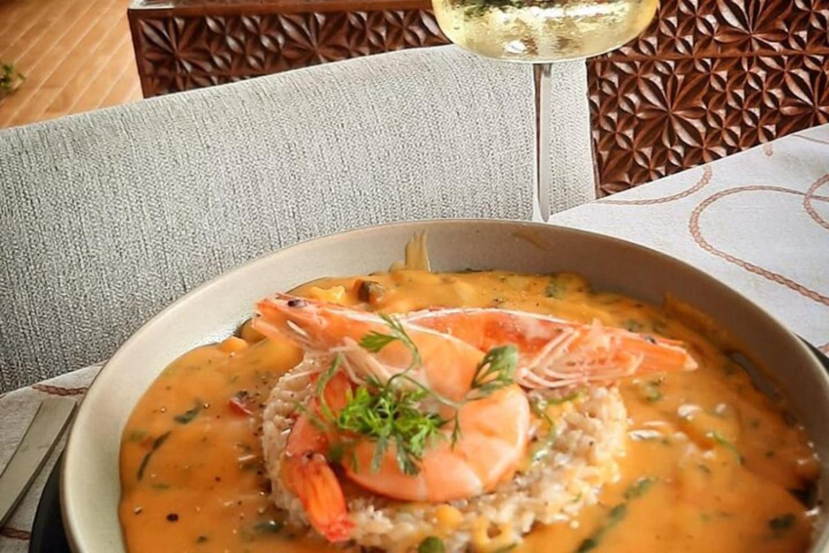 en bolle med suppe med reker og ris på et bord