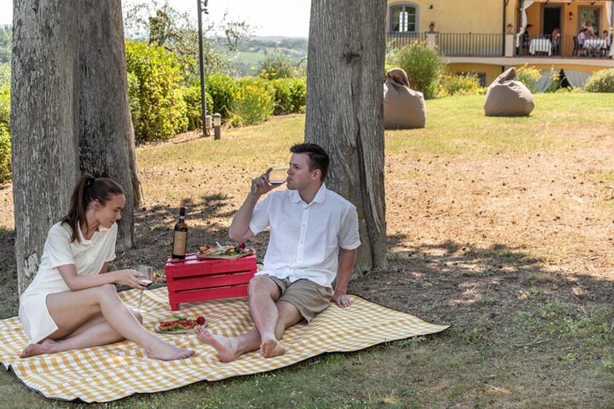 un bărbat și o femeie așezați pe o pătură de picnic
