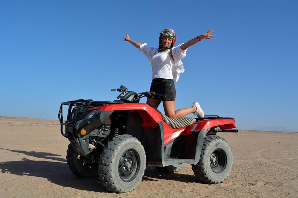 Egy nő ül egy ATV-n a sivatagban