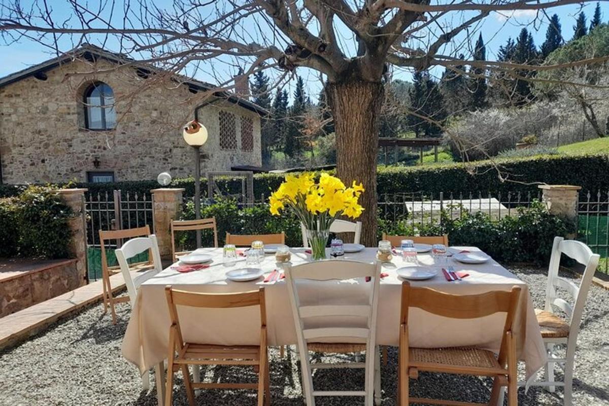 un tavolo con sedie bianche e un tavolo con fiori gialli