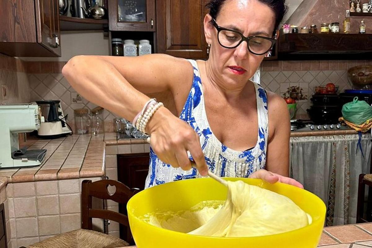 egy nő ételt kever egy tálban a konyhában