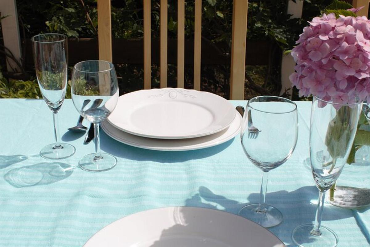 uma mesa com um prato e taças de vinho sobre ela