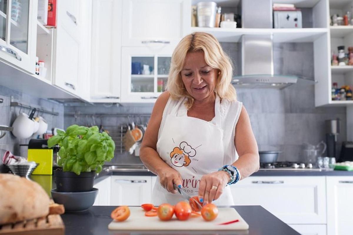 žena v kuchyni krájí rajčata na prkénku