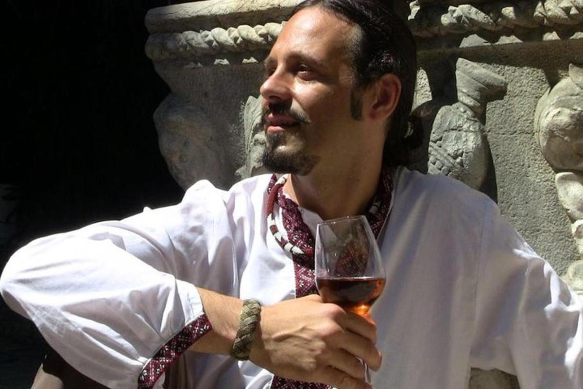 ένας άντρας κρατάει ένα ποτήρι κρασί