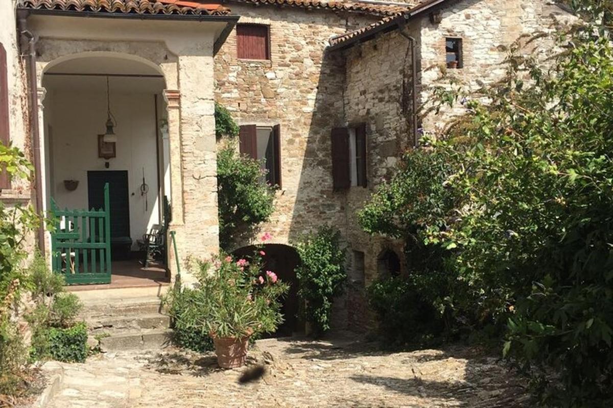 uma casa de pedra com uma porta verde e um quintal