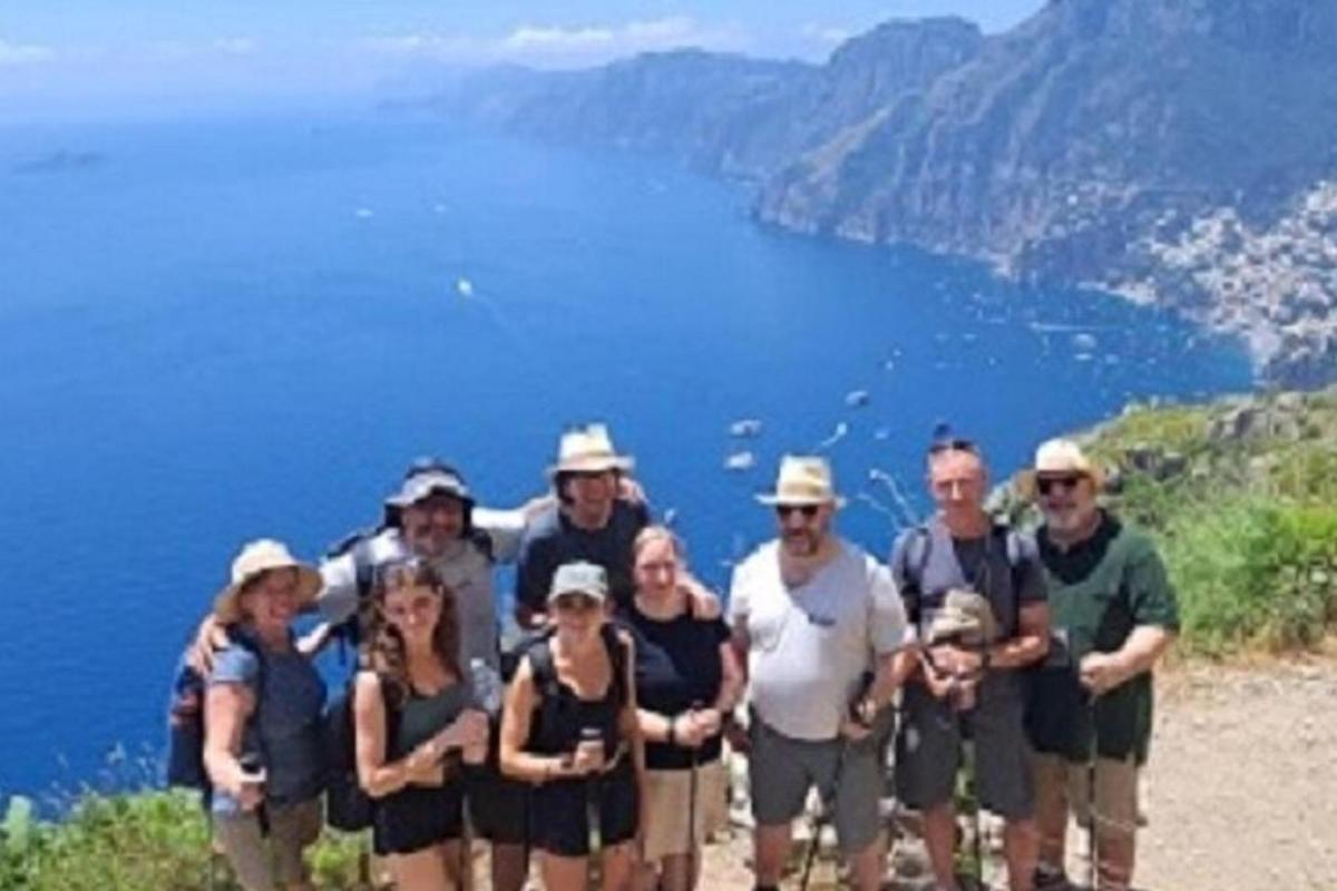 μια ομάδα ανθρώπων που ποζάρουν για μια φωτογραφία σε ένα βουνό