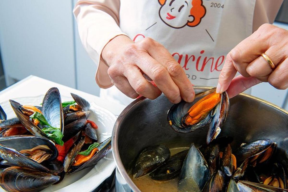 una persona està cuinant musclos en una paella