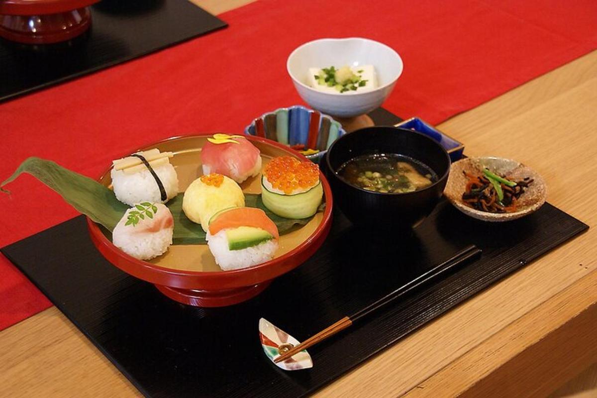 a plate of sushi and a bowl of soup on a table