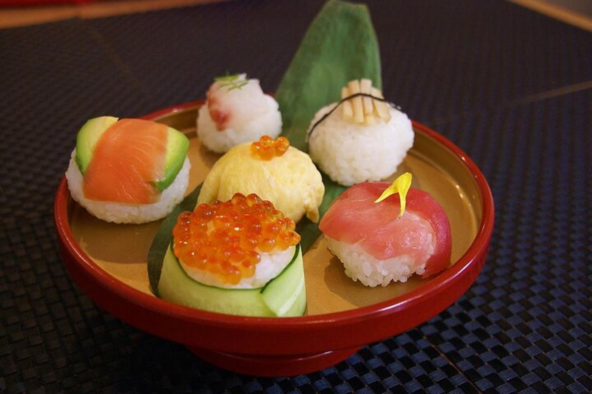 een rode kom gevuld met sushi op een tafel