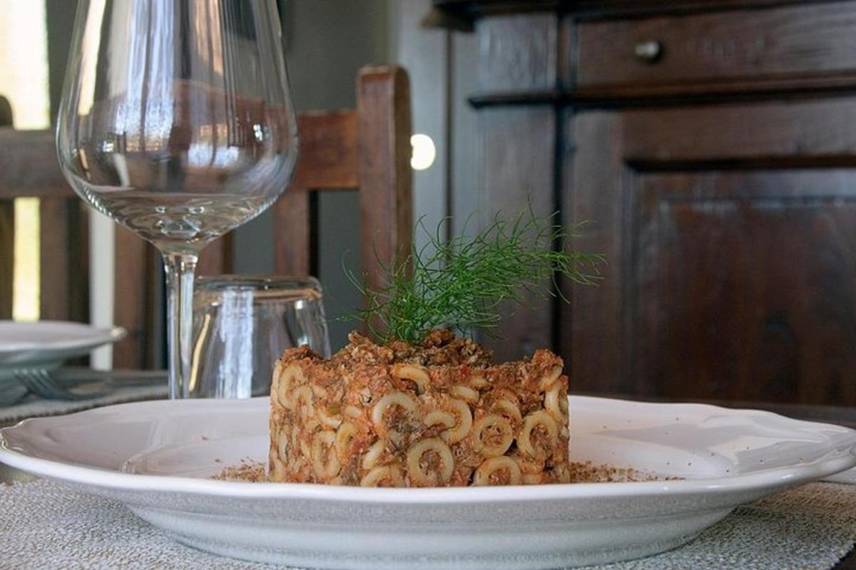 um prato de comida sobre a mesa com uma taça de vinho