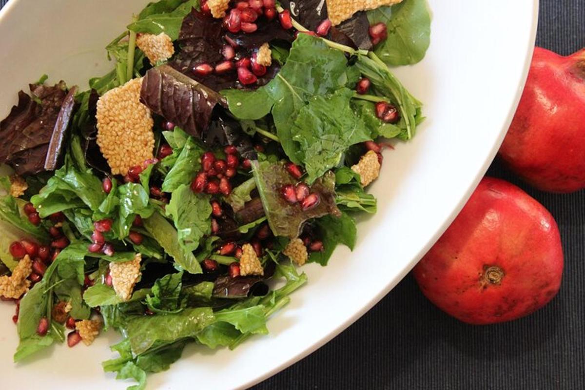 en salat i en hvit tallerken på et bord med epler