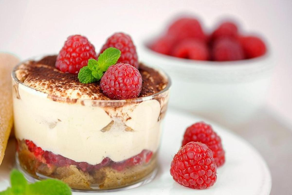 Un postre con frambuesas en un tarro en un plato.