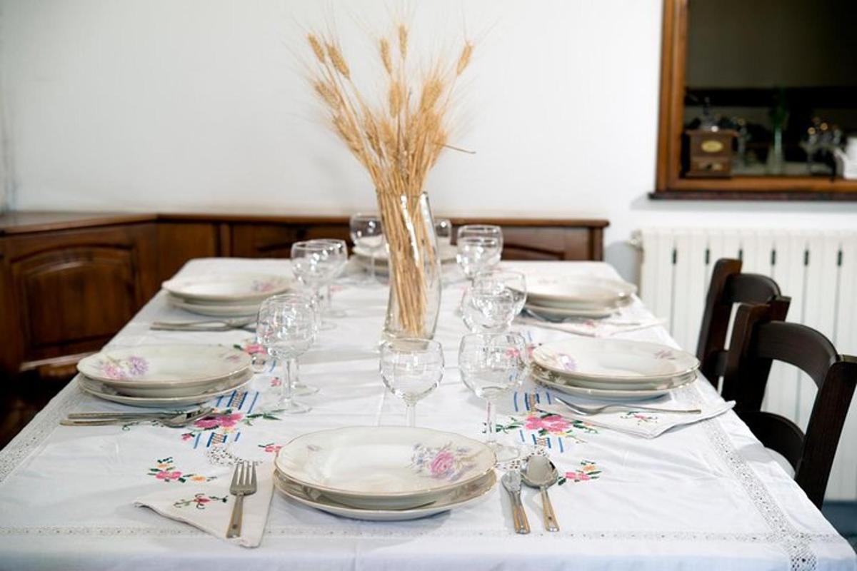 Una mesa con platos y vasos y flores encima.