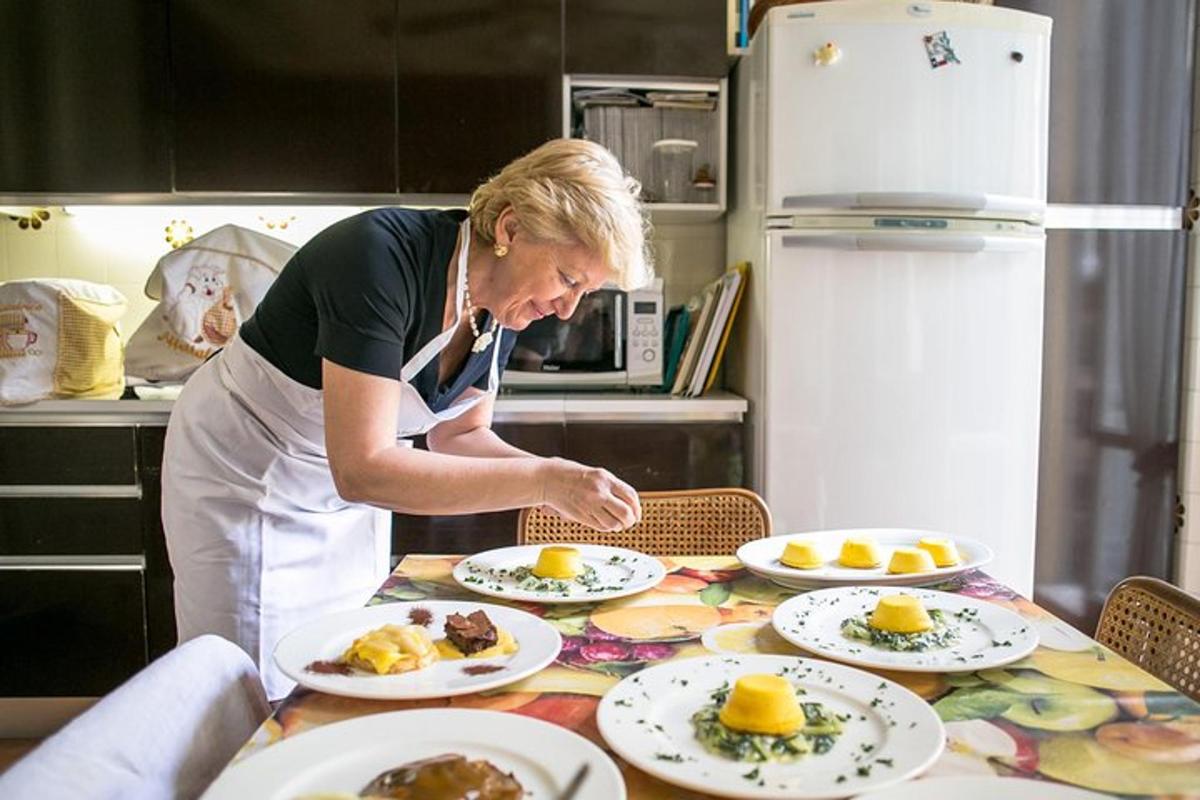 uma mulher em uma cozinha preparando comida em uma mesa
