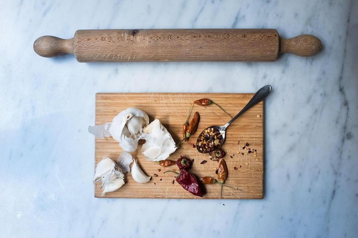 a wooden cutting board with mushrooms and a wooden spoon