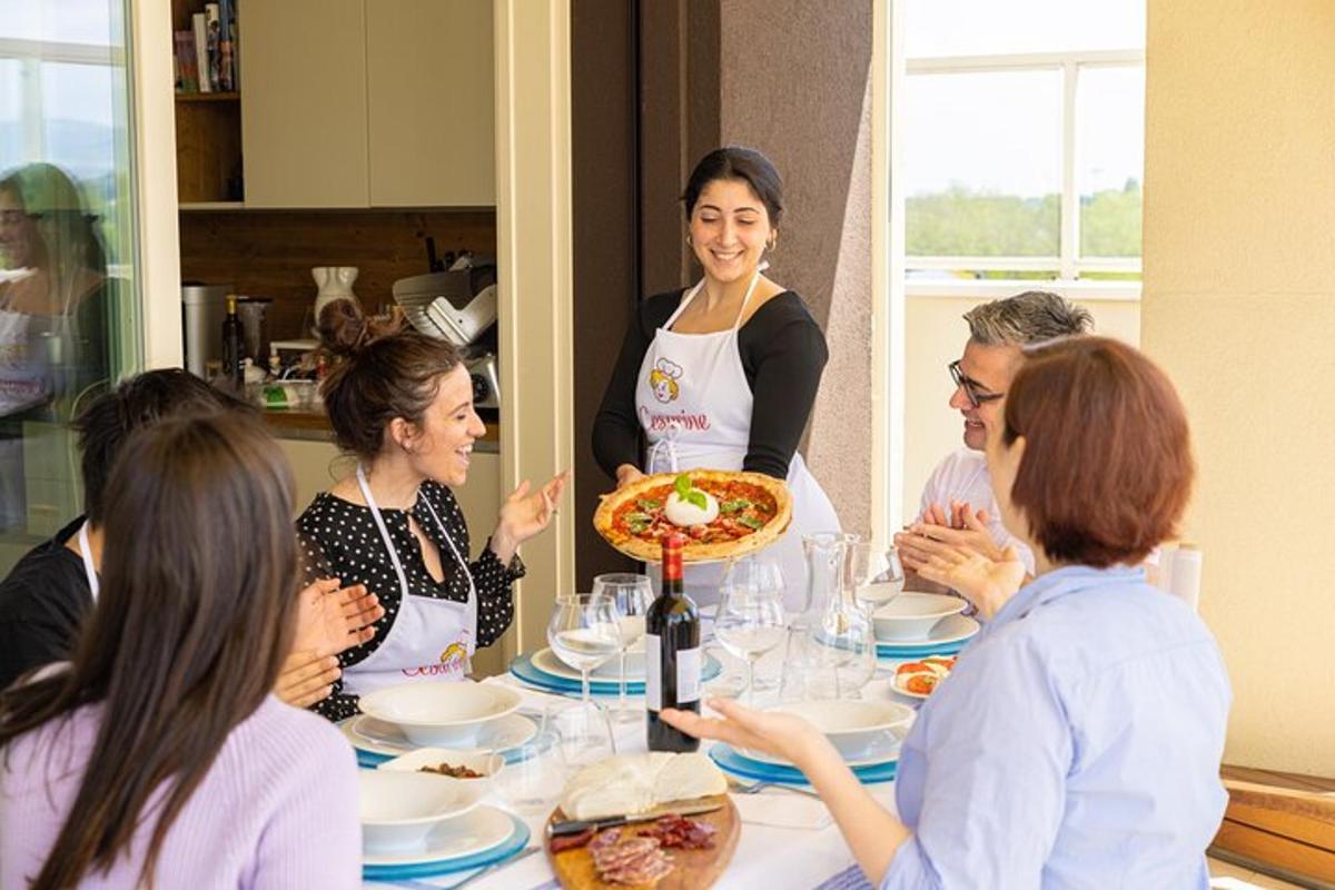 un gruppo di persone sedute attorno a un tavolo con una pizza