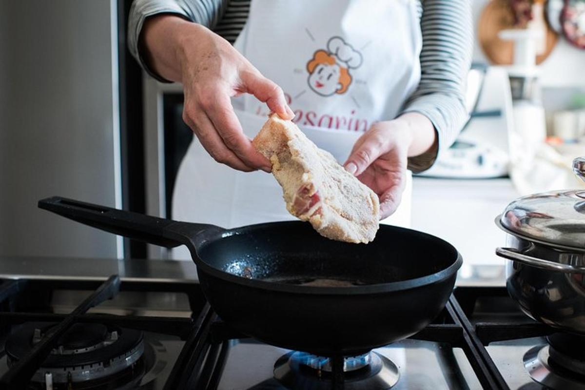 osoba držící kus chleba vařící se ve woku