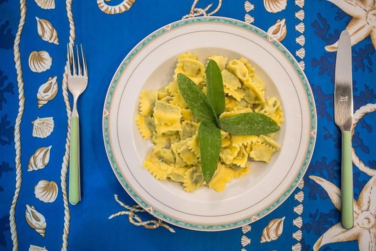 un piatto di pasta alla salvia su un tavolo blu