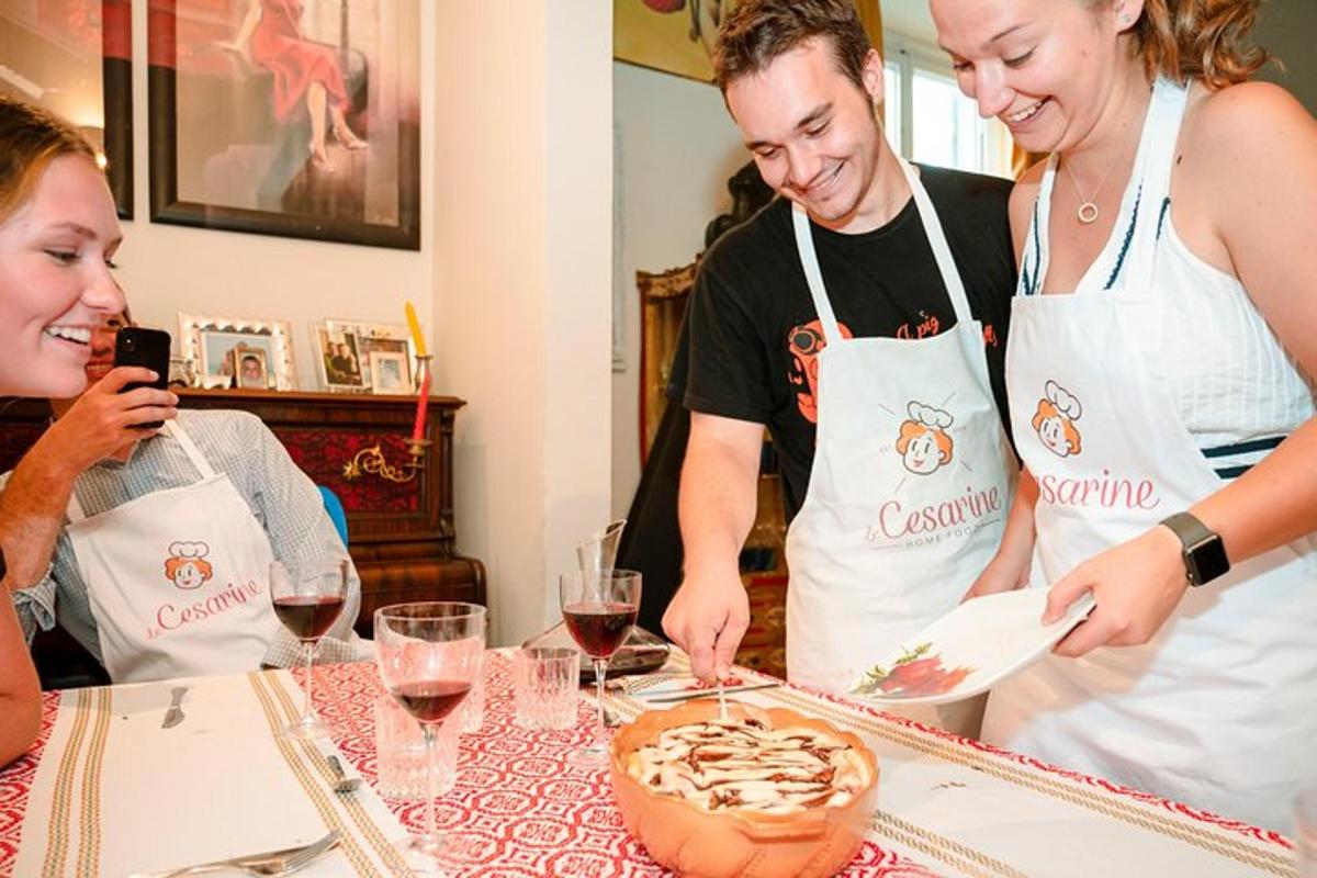 un uomo e due donne in grembiule che preparano una torta