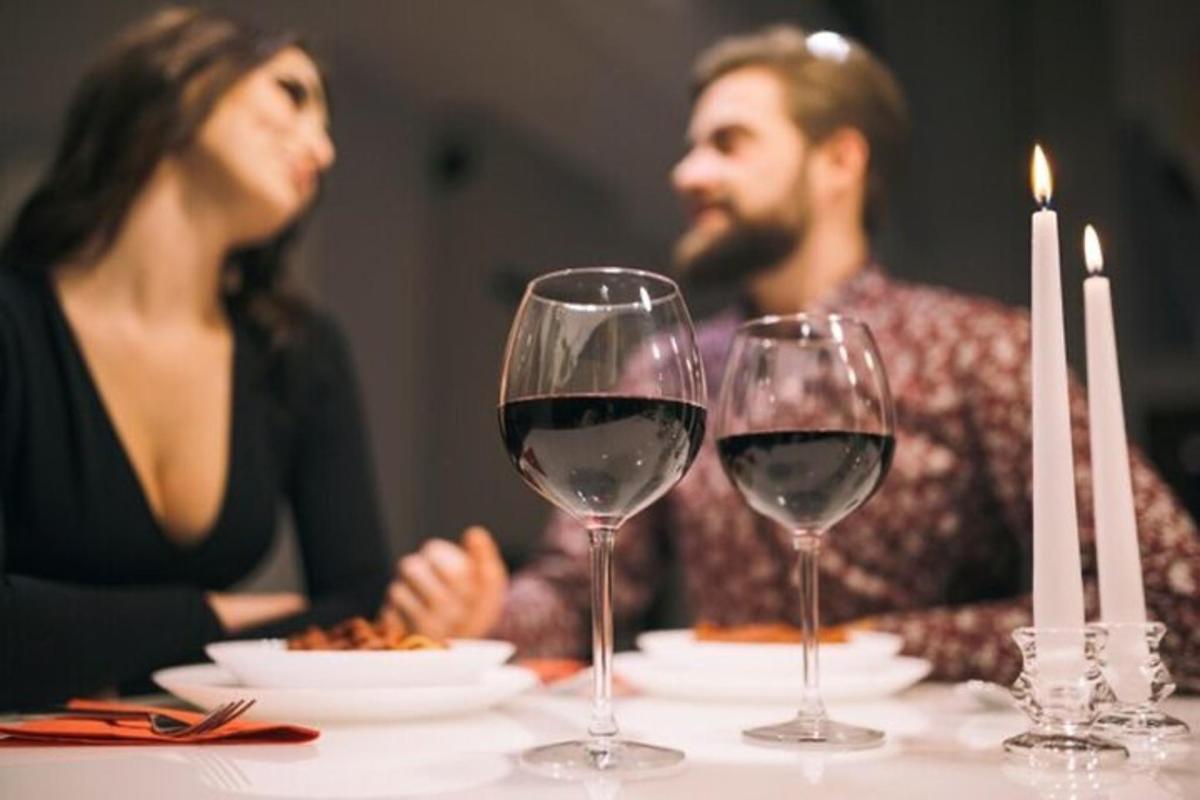 Ein Mann und eine Frau sitzen mit Weingläsern an einem Tisch