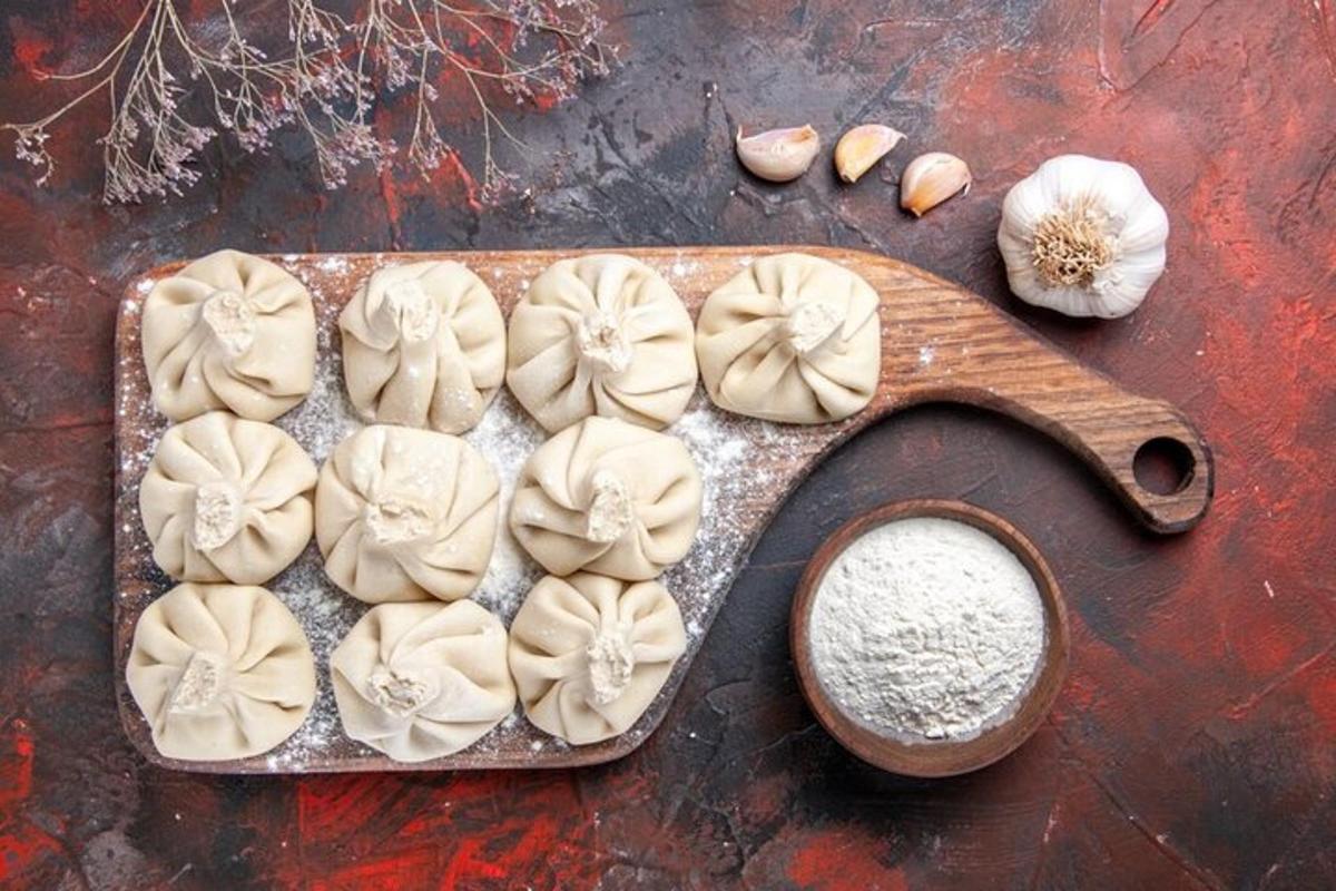 et skærebræt med dumplings og en skål hvidløg