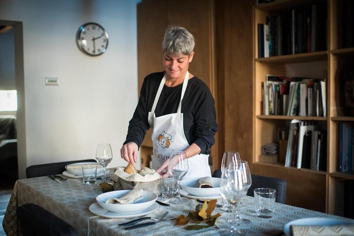 un home amb davantal preparant menjar a taula