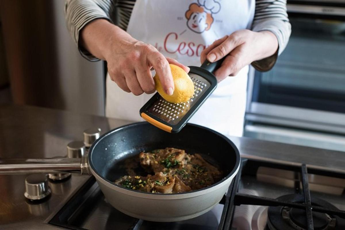 osoba držící citron v hrnci s jídlem