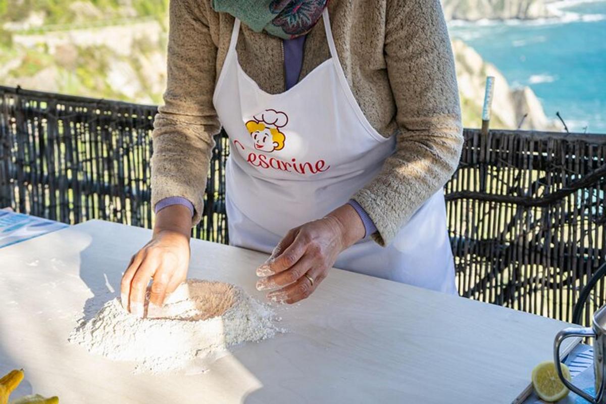 una persona con un grembiule che prepara il cibo su un tavolo