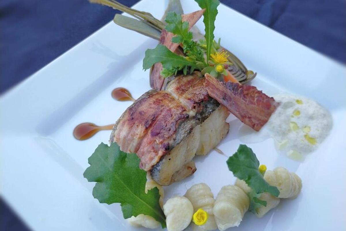 um prato branco com um pedaço de carne e vegetais