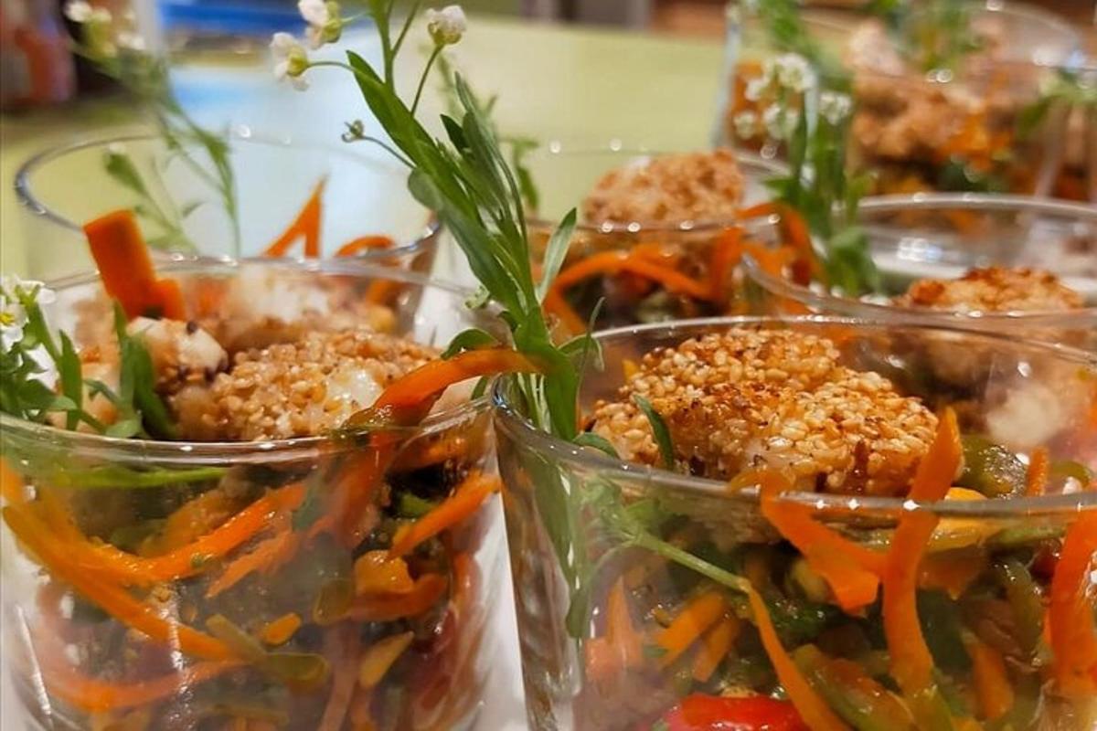 um grupo de copos plásticos cheios de vegetais sobre uma mesa