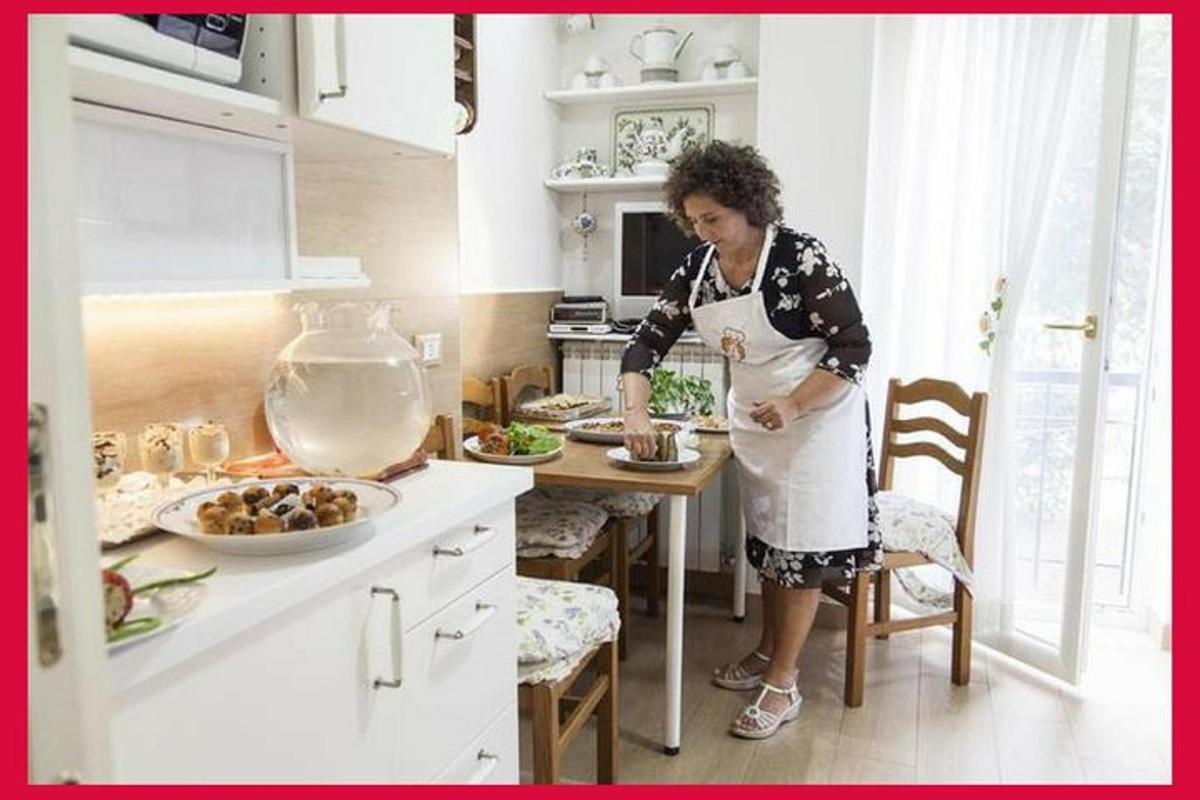 una dona dempeus a la cuina preparant menjar
