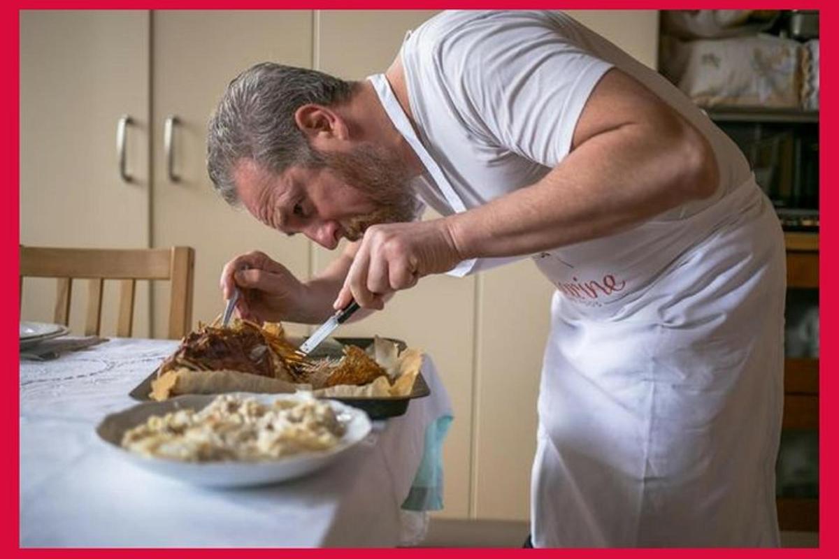 un bărbat în bucătărie pregătește mâncare pe masă