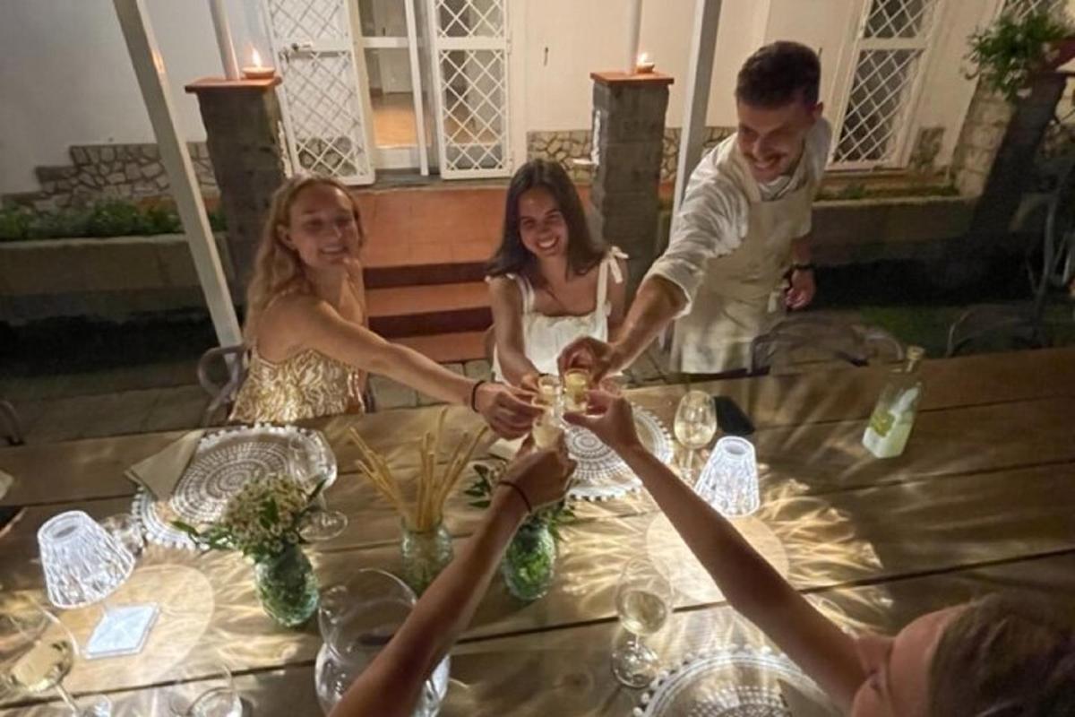 un gruppo di persone sedute attorno a un tavolo con bicchieri di vino