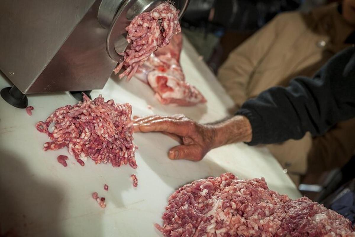 una persona cortando carne encima de una mesa
